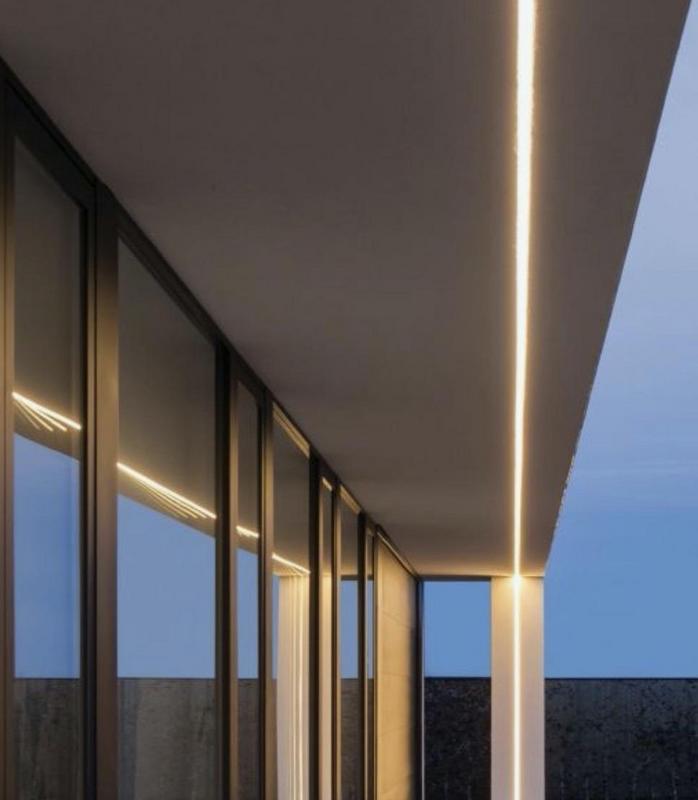 Современное архитектурное освещение фасада частного дома с использованием светодиодных линейных систем и направленных светильников