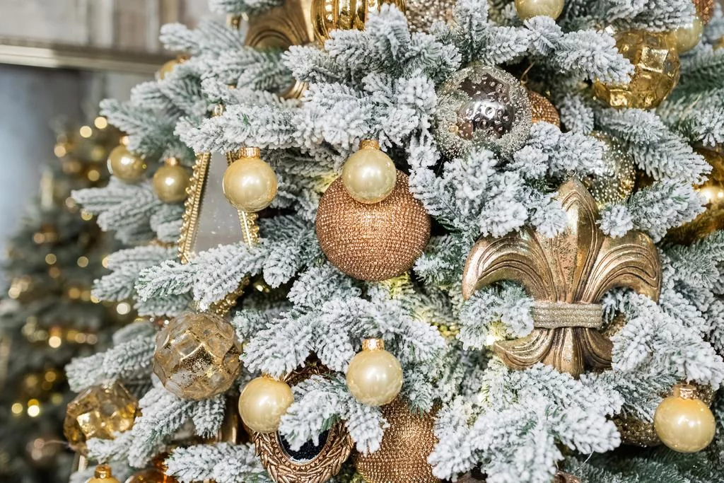 Минималистичное украшение уличной елки деревянными игрушками в природных тонах на фоне зимнего пейзажа