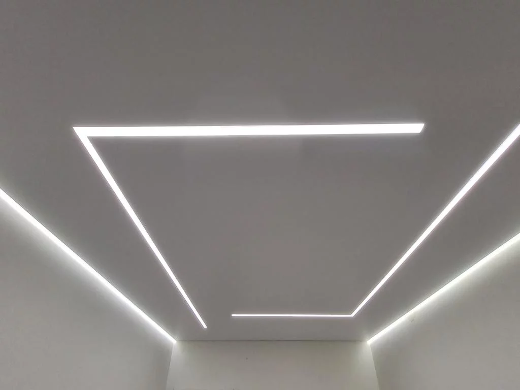 Современный натяжной потолок с неоновой подсветкой по периметру, создающий эффект парящего потолка в интерьере гостиной