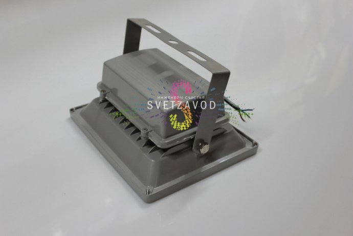 Детальное фото зеленого светодиодного прожектора 50Вт. Видны металлический серый корпус, поворотный механизм, защитное стекло и клеммная коробка для подключения.