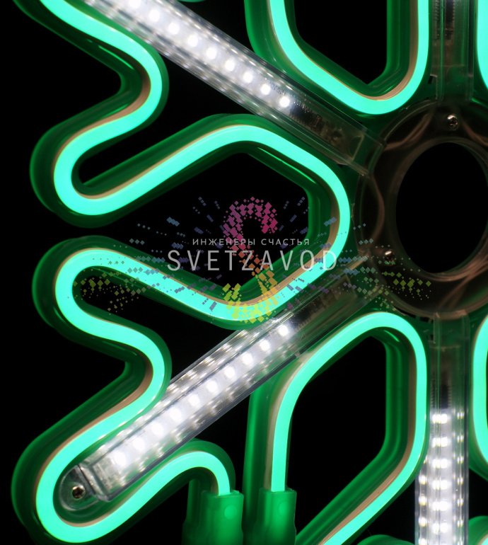 Крупный план зеленой светодиодной снежинки 40 см с неоновым свечением и эффектом тающих сосулек, установленной на фасаде здания.