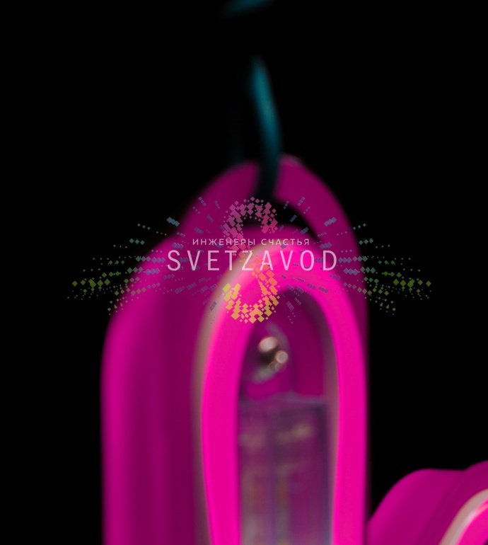 Крупный план розовой светодиодной снежинки из гибкого неона на пластиковом каркасе, демонстрирующий эффект плавно стекающих сосулек. Видно крепежное ушко и кабель питания.