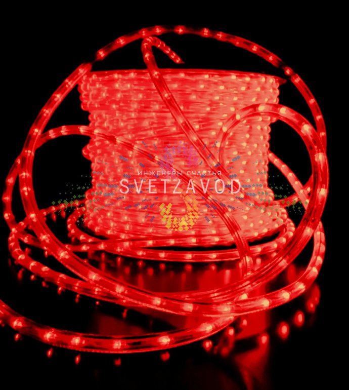 Крупный план светящегося круглого дюралайта красного свечения с прозрачной оплеткой, диаметр 13мм, подключен к сети 220В.