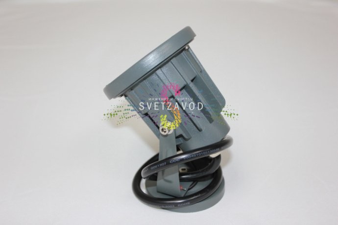 Детальное изображение светодиодного прожектора: серый металлический корпус, поворотный механизм, прозрачное защитное стекло, красные светодиоды.