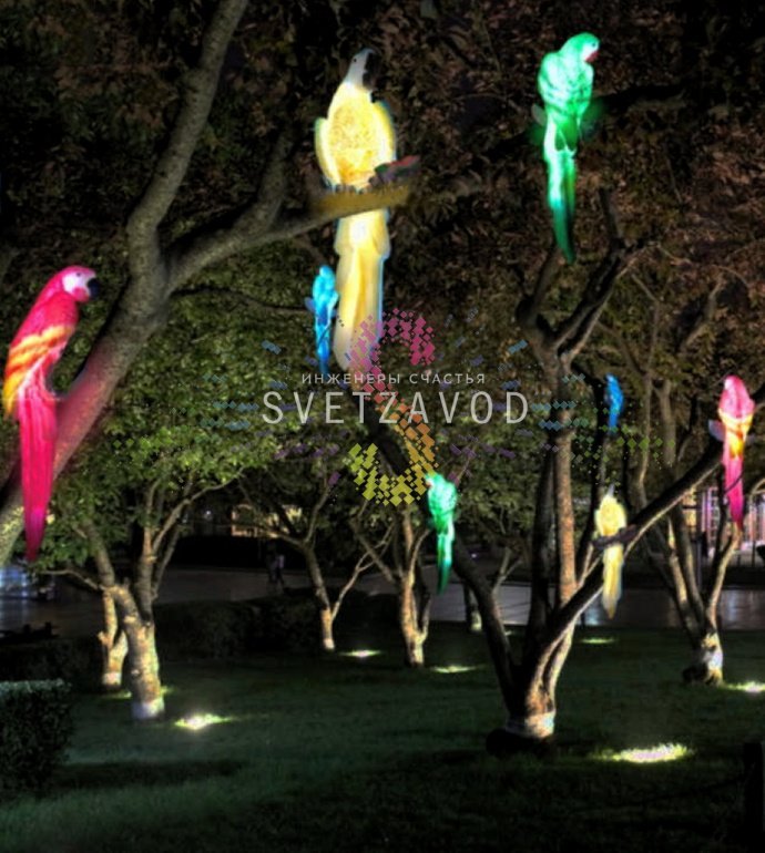 Детальное фото набора светодиодных фигур Попугаев из белого стекловолокна с яркой разноцветной светодиодной подсветкой в вечернем саду.