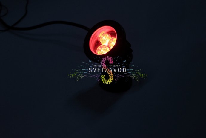 Детальное изображение светодиодного прожектора: серый металлический корпус, поворотный механизм, прозрачное защитное стекло, красные светодиоды.