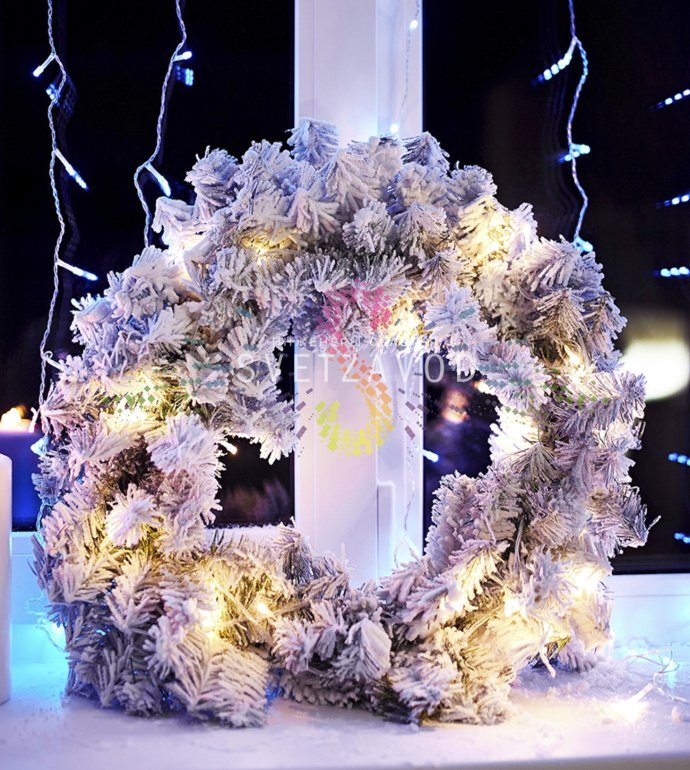 Детальное фото рождественского венка Neon-Night: реалистичные заснеженные ветки ПВХ, пышный объем, диаметр 45 см, темно-зеленая основа с белым покрытием.
