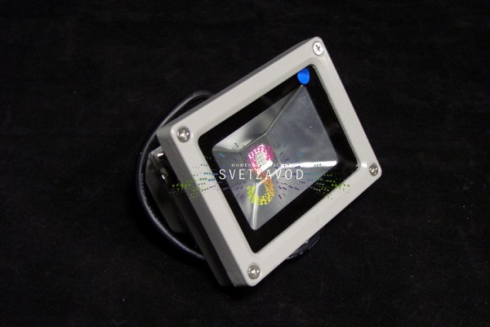 Детальное фото синего светодиодного прожектора 10Вт 220В. Виден металлический серый корпус, поворотный механизм, стеклянный рассеиватель и крепление для накладного монтажа.