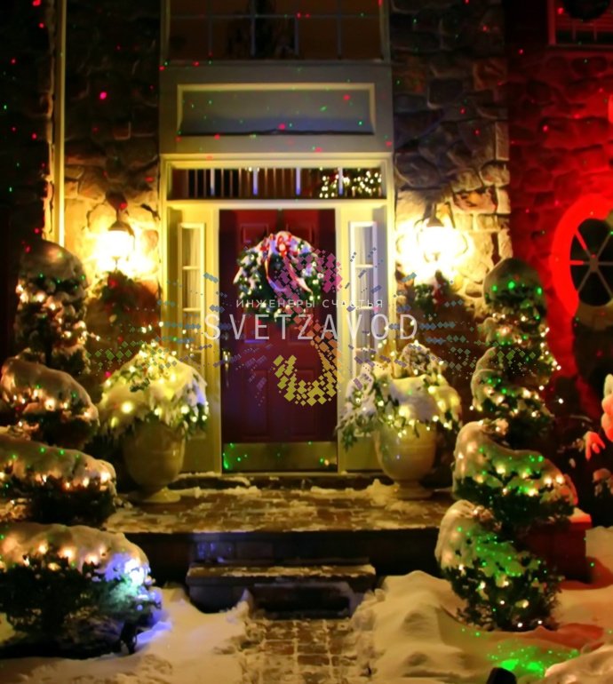 Лазерный проектор Garden X-30 Premium (X-38) в работе, создает зеленые и красные лазерные узоры анимации 'Светлячок' на стене, установлен на грунтовом основании.