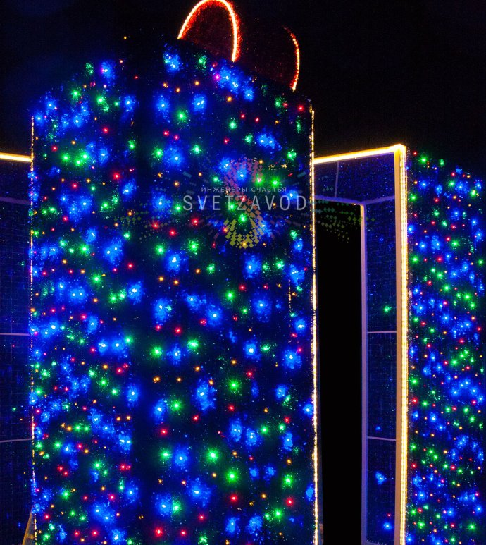 Детальное фото световой конструкции Подарок 300х300х400 см. Виден прочный стальной каркас, светодиодные гирлянды, мишура и бант. Конструкция предназначена для уличного использования.