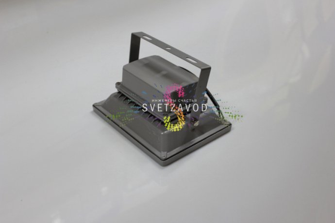 Крупный план синего светодиодного прожектора мощностью 20Вт в сером алюминиевом корпусе с крепежными элементами и прозрачным стеклянным рассеивателем.