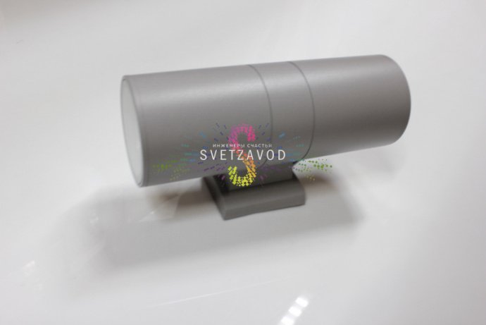 Детальное фото двухстороннего светодиодного прожектора мощностью 18Вт. Виден серый алюминиевый корпус, два световых модуля, крепежные элементы и прозрачные стеклянные рассеиватели.