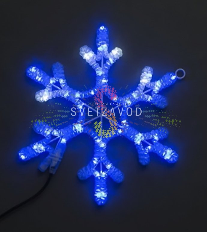 Крупный план синей светодиодной снежинки на металлическом каркасе с вилкой для подключения к сети 220В.