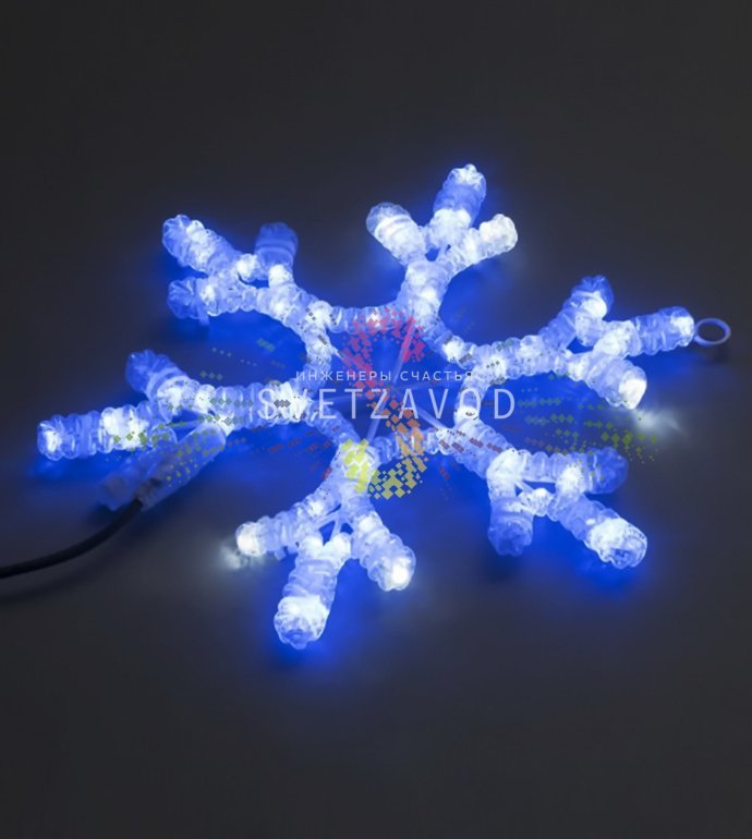 Крупный план синей светодиодной снежинки на металлическом каркасе с вилкой для подключения к сети 220В.
