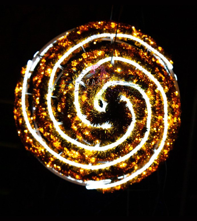 Крупный план светодиодной елки Конус с золотой мишурой, стальным каркасом и теплым белым свечением, установленной на улице.