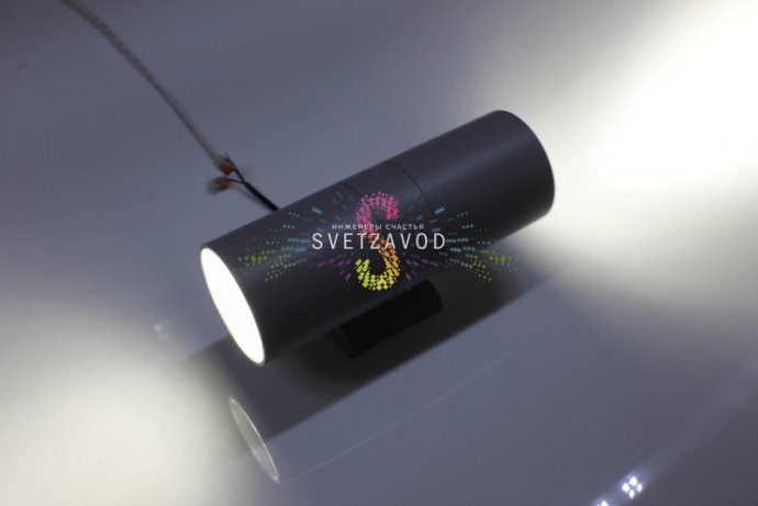 Детальное фото двухстороннего светодиодного прожектора мощностью 18Вт. Виден серый алюминиевый корпус, два световых модуля, крепежные элементы и прозрачные стеклянные рассеиватели.