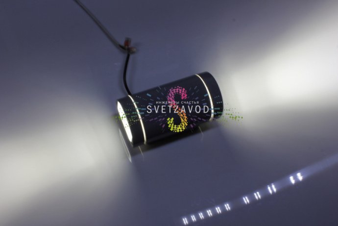 Крупный план двухстороннего светодиодного прожектора в сером металлическом корпусе с полукруглым рассеивателем, видна маркировка и крепление